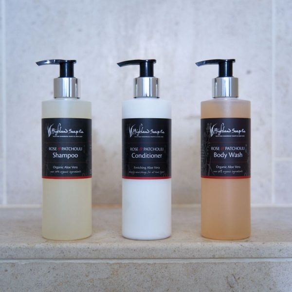 Rose & Patchouli Haar- en Bodyverzorging | Highland Soap Company Rose & Patchouli shampoo, conditioner en body wash van The Highland Soap Company op een lichte stenen achtergrond
