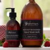 Wild Scottish Raspberry hand wash en grote refillfles van The Highland Soap Company met verse frambozen op de voorgrond