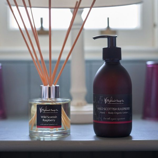 Wild Scottish Raspberry diffuser en hand- en bodylotion op een stijlvolle tafel in een zachte, huiselijke setting.