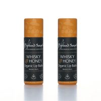Twee Whisky & Honey lippenbalsems van The Highland Soap Company rechtop naast elkaar op een lichte achtergrond.