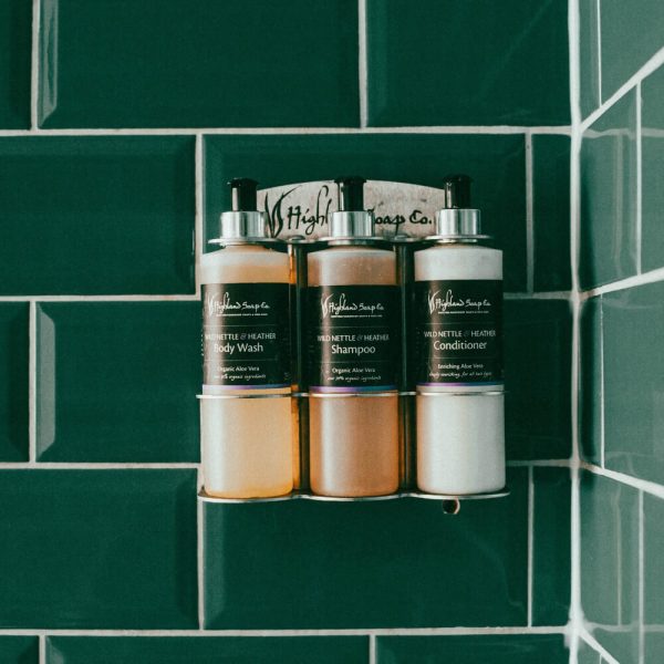 Wild Nettle & Heather – Badkamerverzorging – wandhouder met bodywash, shampoo en conditioner tegen groene tegelwand