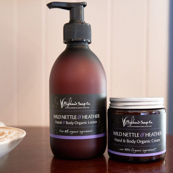 Wild Nettle & Heather – Bodylotion & Crème – amberkleurige pompflacon en verzorgingspot op houten oppervlak