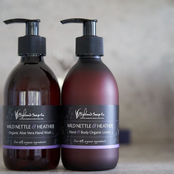 Wild Nettle & Heather – Handzeep & Bodylotion – twee amberkleurige pompflacons op lichte achtergrond