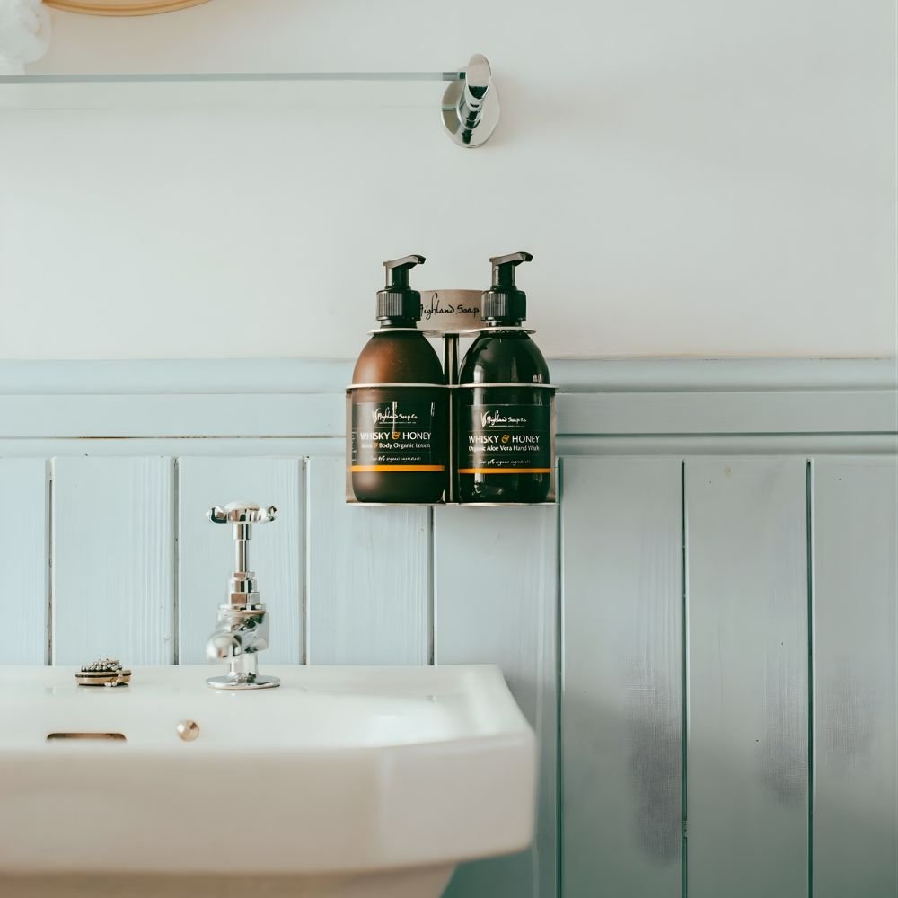 Handzeep en lotion van The Highland Soap Company in een houder aan de muur boven de wastafel