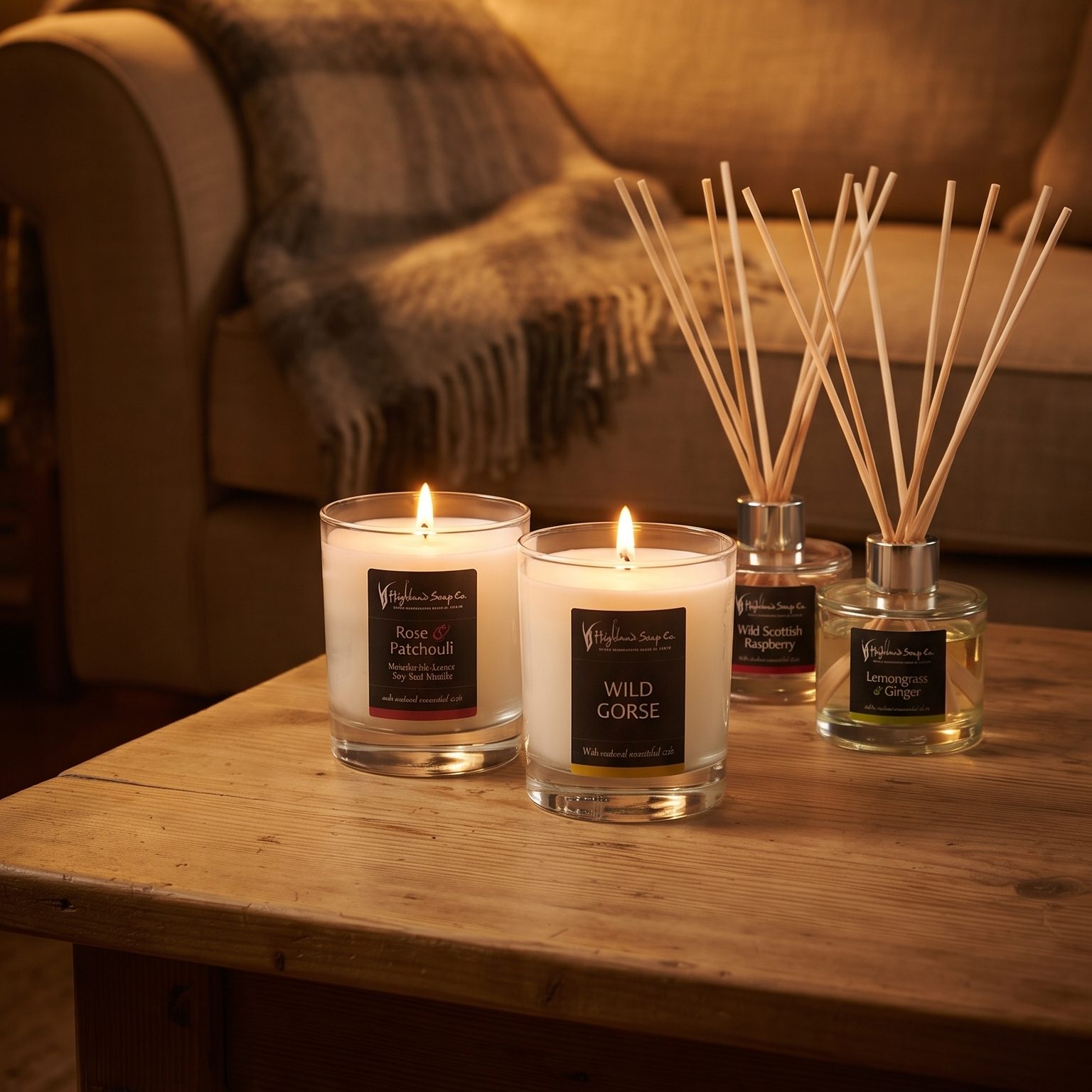 Twee geurkaarsen en twee geurstokjes van The Highland Soap Company op een salontafel, de voordeelsets