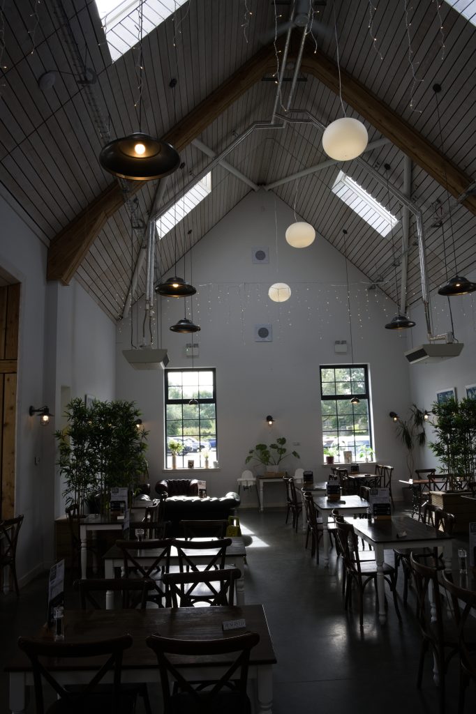 Het Larder Café van The Highland Soap Company, met een hoge houten kap en lange tafels