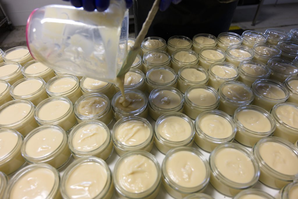 Glazen potjes worden in de werkplaats met de hand gevuld