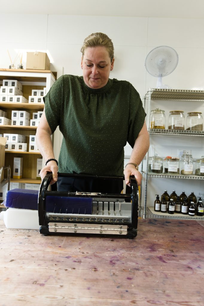 José Prins duwt zelf een baar zeep door de snijder bij The Highland Soap Company