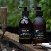 Gardeners Vloeibare Handzeep en Hand & Body Lotion van The Highland Soap Company in de tuin, naast een schepje