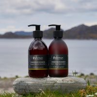 Voordeelset handzeep en hand en body lotion - Hebridean Seaweed Hebridean Seaweed handzeep en hand & body lotion van The Highland Soap Company op een steen aan het water