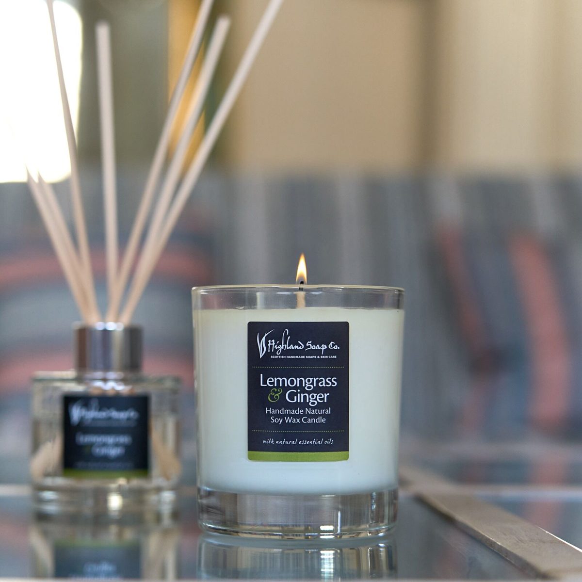 Lemongrass & Ginger geurstokjes naast een brandende Lemongrass & Ginger geurkaars