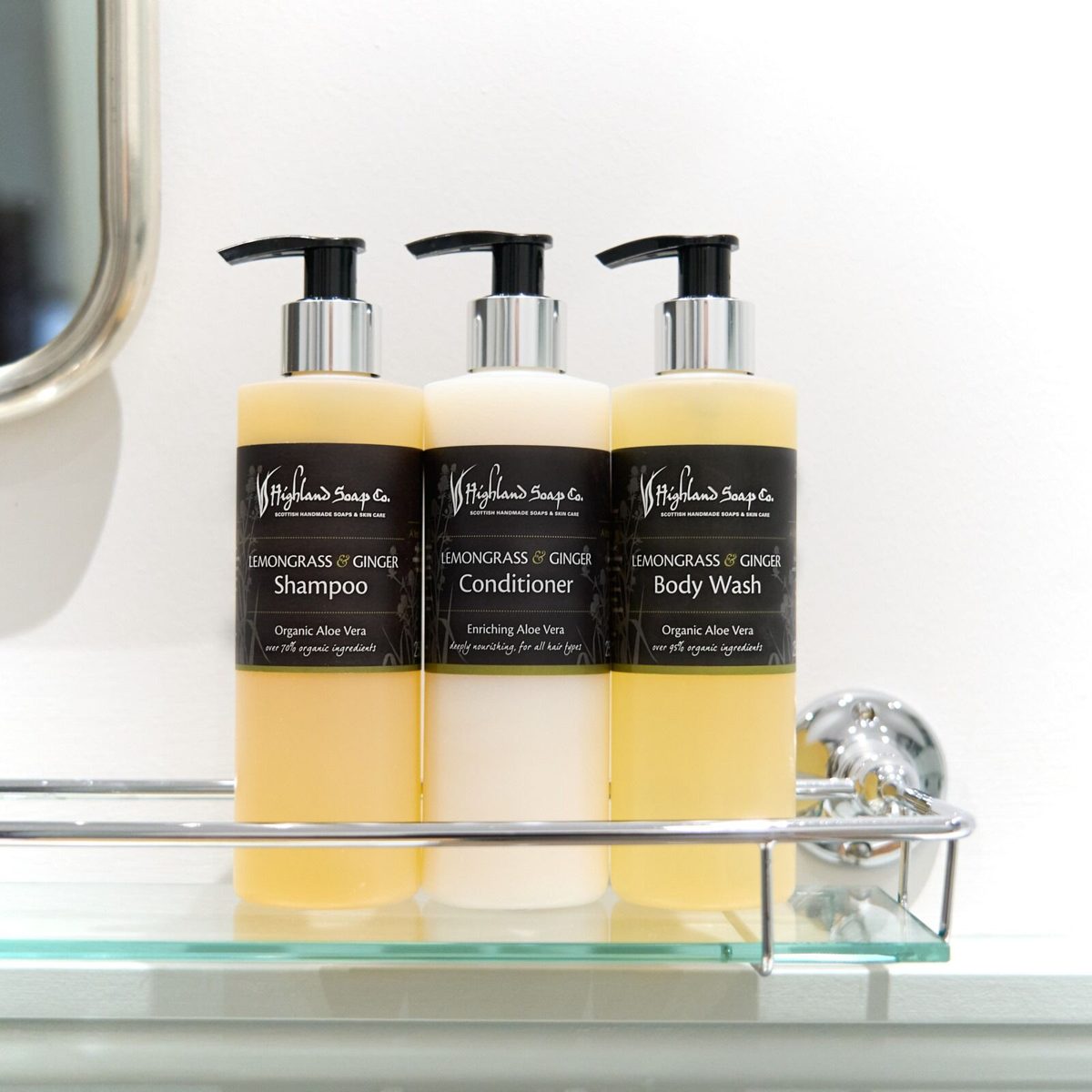 Lemongrass & Ginger shampoo, conditioner en douchegel op een glazen plankje in de badkamer