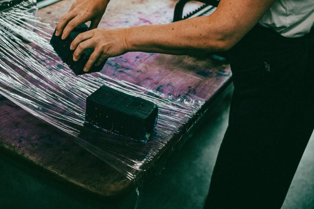 Een blok ambachtelijke zeep van The Highland Soap Company wordt met de hand gesneden