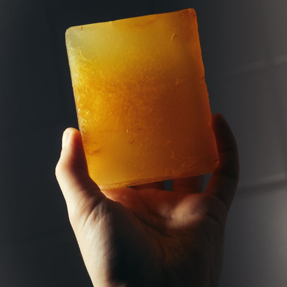 Een amberkleurig blok Whisky & Honey zeep in het licht
