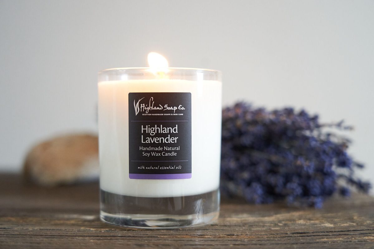 Een brandende geurkaars Highland Lavender van The Highland Soap Company met een bosje gedroogde lavendel